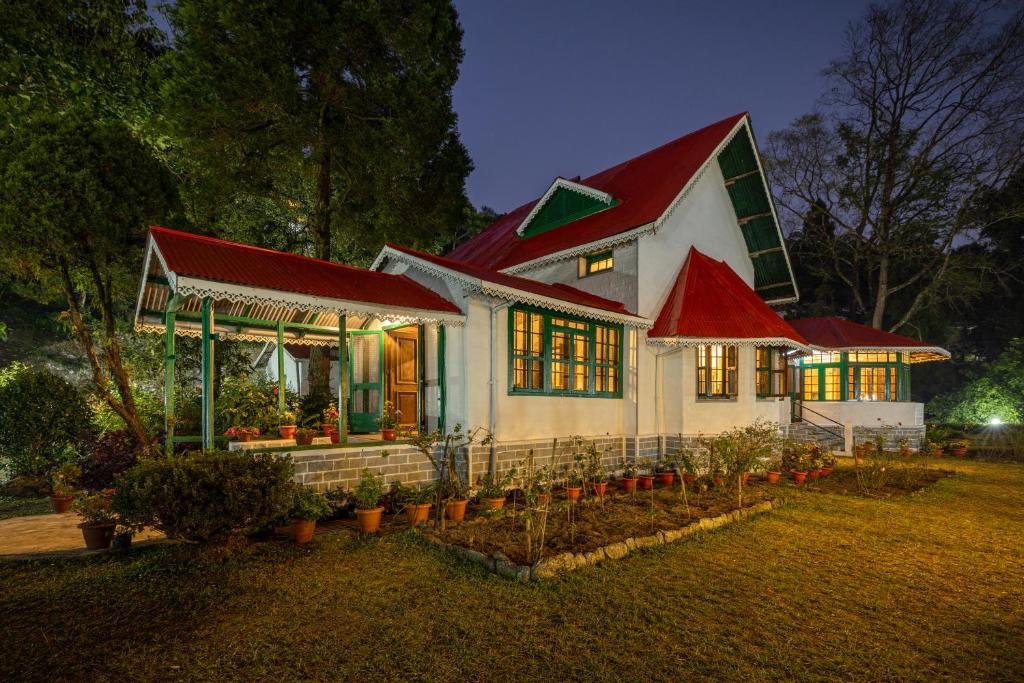 una casa con techo rojo con plantas delante en amã Stays & Trails - Wayside Villa, Kurseong, en Karsiyang