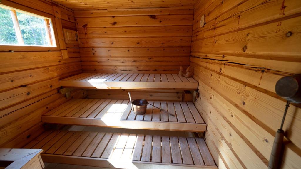 an empty wooden sauna with a bucket in it at Villa Mustikka in Ekenäs
