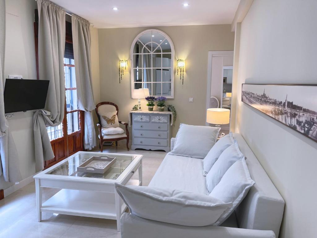- un salon avec un canapé blanc et une table dans l'établissement Apartamento Arquillo de la Plata, à Séville