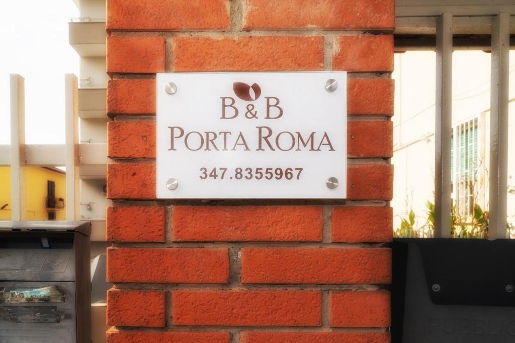a sign on the side of a brick wall at B&B Porta Roma in Capua