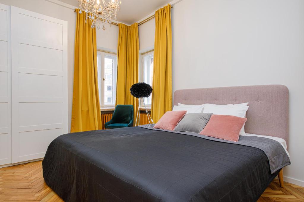 a bedroom with a large bed and yellow curtains at Apartment Peegel in city center free parking in Tallinn