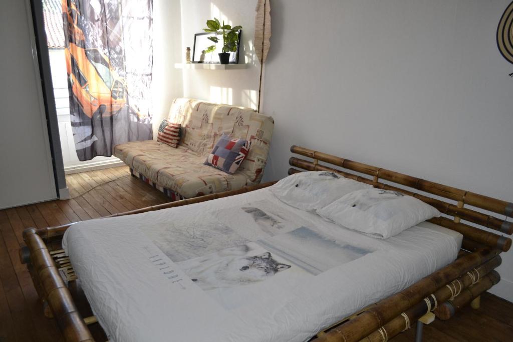 a bed and a chair in a room at Belle chambre d'hôte pour 2 à 4 PERSONNES in Chef-Boutonne