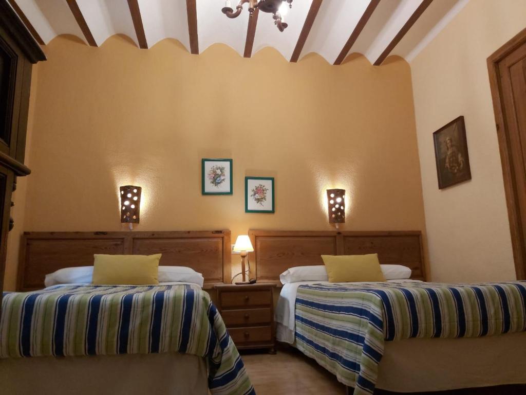 um quarto com 2 camas e um tecto em Apartamentos Tío José María em Hinojares