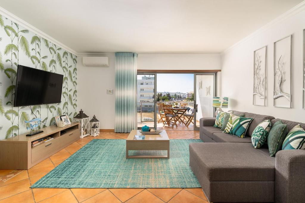 uma sala de estar com um sofá e uma televisão em Sea La Vie Beach & Golf Apartment em Lagos