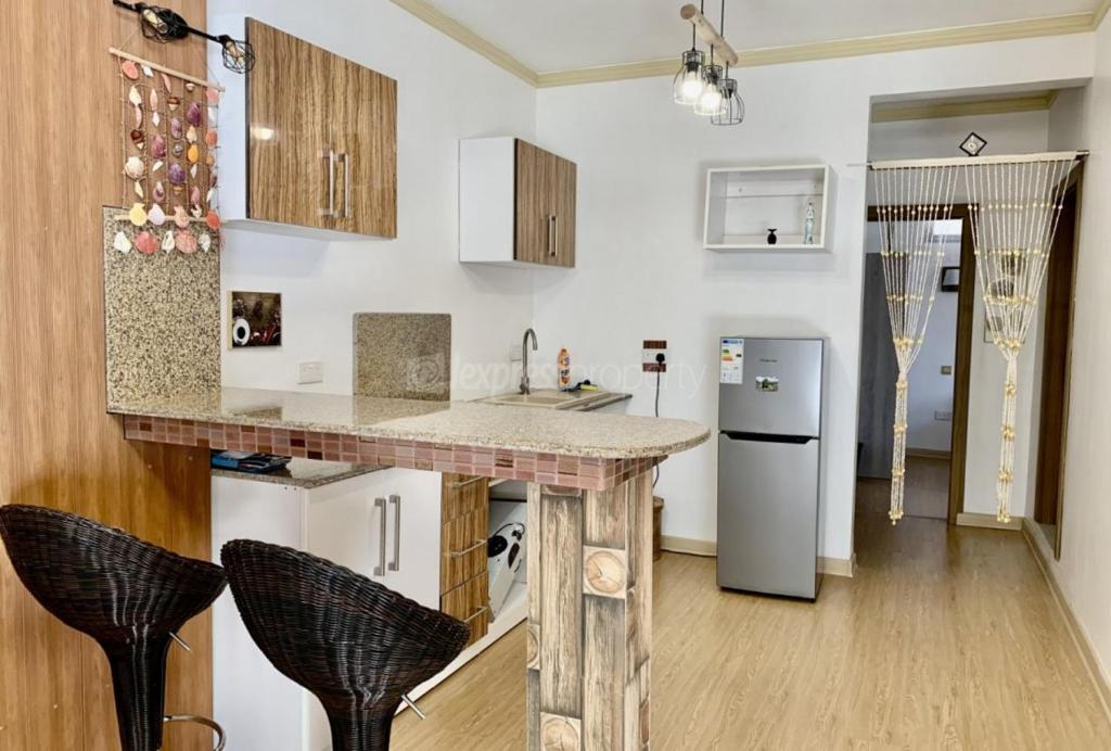 a kitchen with a counter and some chairs in it at BaliApartments in Grand-Baie