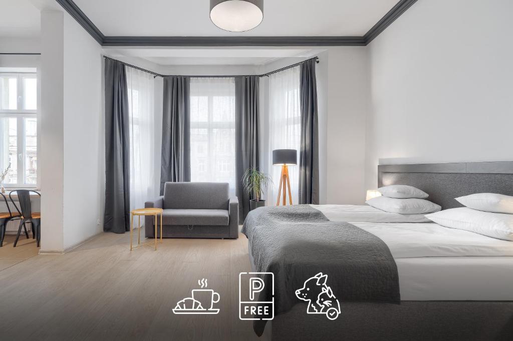 um quarto com uma cama, uma cadeira e janelas em Aparthotel Platinum em Szczecin