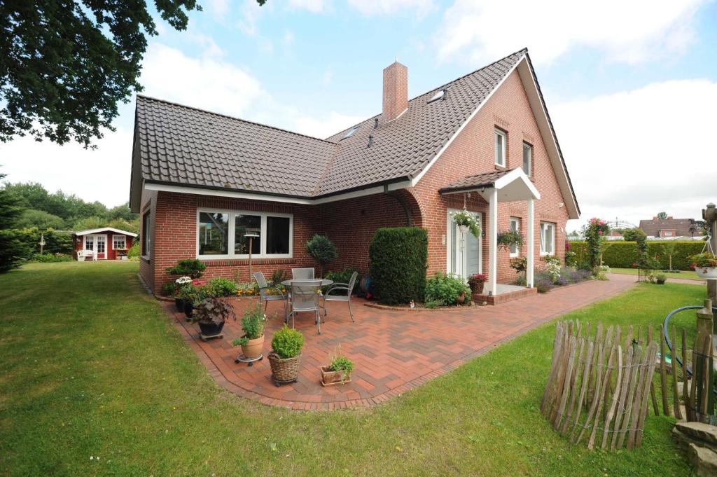a house with a brick patio in the yard at Ferienwohnung Zum Königsmoor 65336 in Moormerland