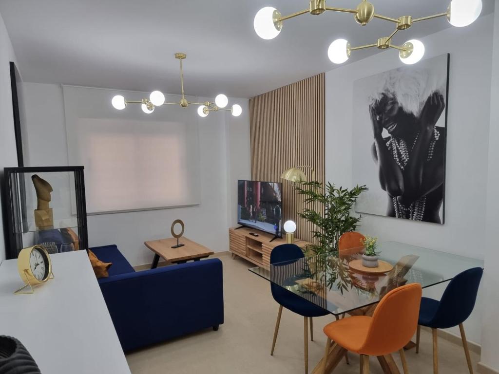 a living room with a blue couch and a table at Apartamento Luz del Mediterraneo Garrucha in Garrucha