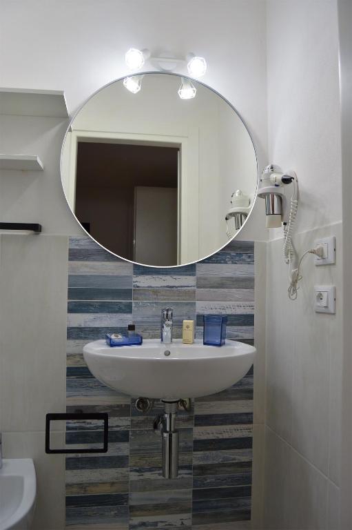a bathroom with a sink and a mirror at Onda Su Onda Appartamenti in Seccheto