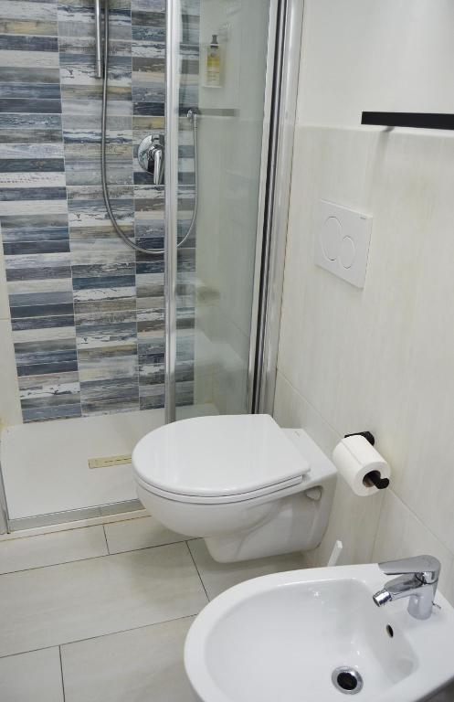 a bathroom with a toilet and a shower and a sink at Onda Su Onda Appartamenti in Seccheto