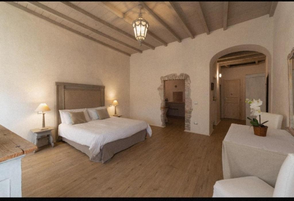 Corte del Cedro في بروفاغليو دلسيو: غرفة نوم كبيرة مع سرير وأريكة