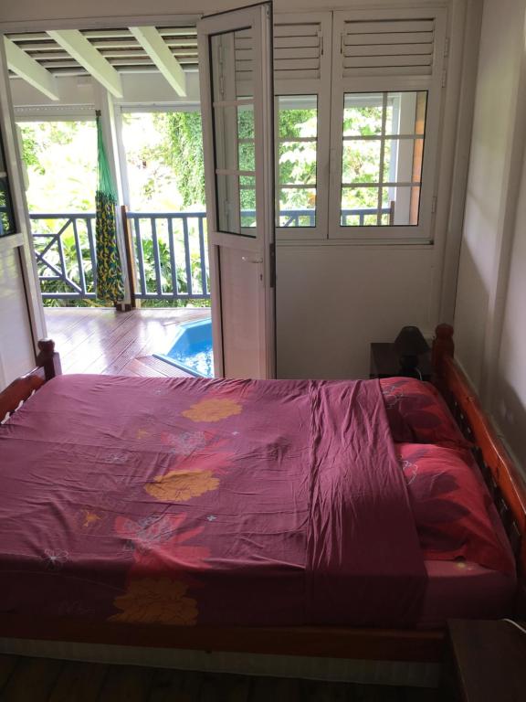 1 dormitorio con 1 cama con edredón morado en LOFT ET VERDURE en Fort-de-France