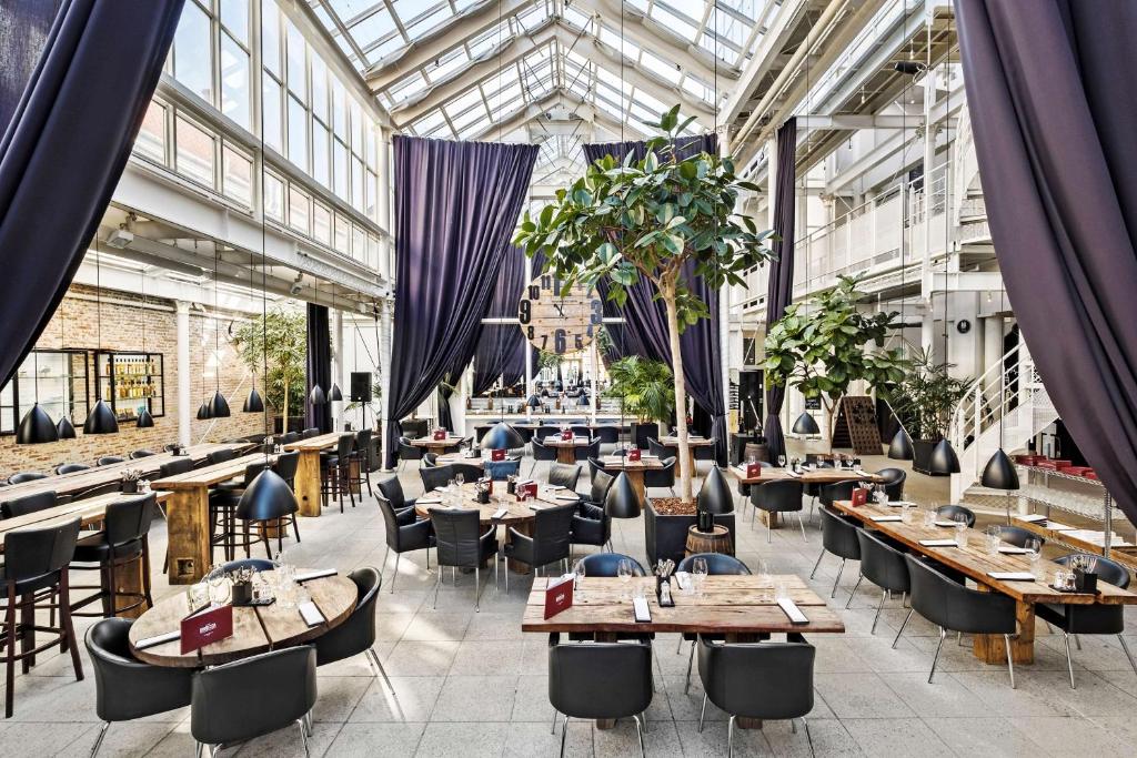 een restaurant met tafels en stoelen en een glazen plafond bij Best Western ToRVEhallerne in Vejle