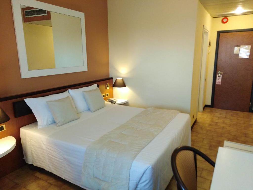 - une chambre d'hôtel avec un lit et un miroir dans l'établissement RHI Porta Bologna, à Pieve di Cento