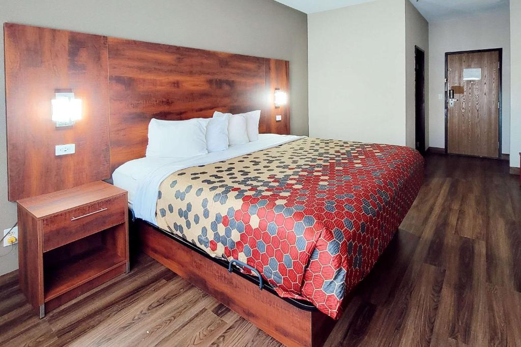 een slaapkamer met een groot bed met een houten hoofdeinde bij Econo Lodge in Fargo