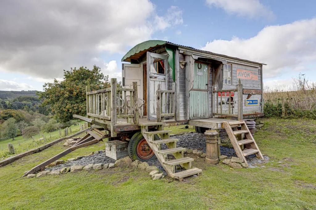 an old truck with a ladder sitting in a field at Glamping Wagon - 1 x Double Bed 2 x Single Bed in Scarborough