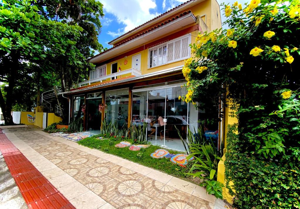 a yellow house with a patio and a garden at Casas Amarelas in Florianópolis