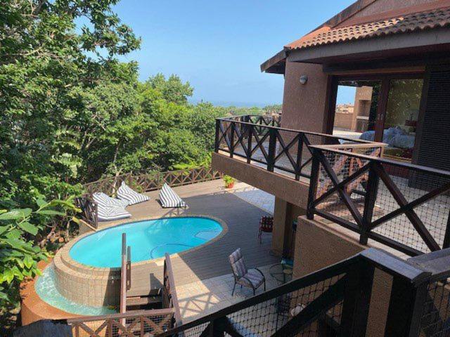 a house with a swimming pool next to a house at San Lameer Villa 11703 - 5 Bedroom Luxury - 10 pax - San Lameer Rental Agency in Southbroom