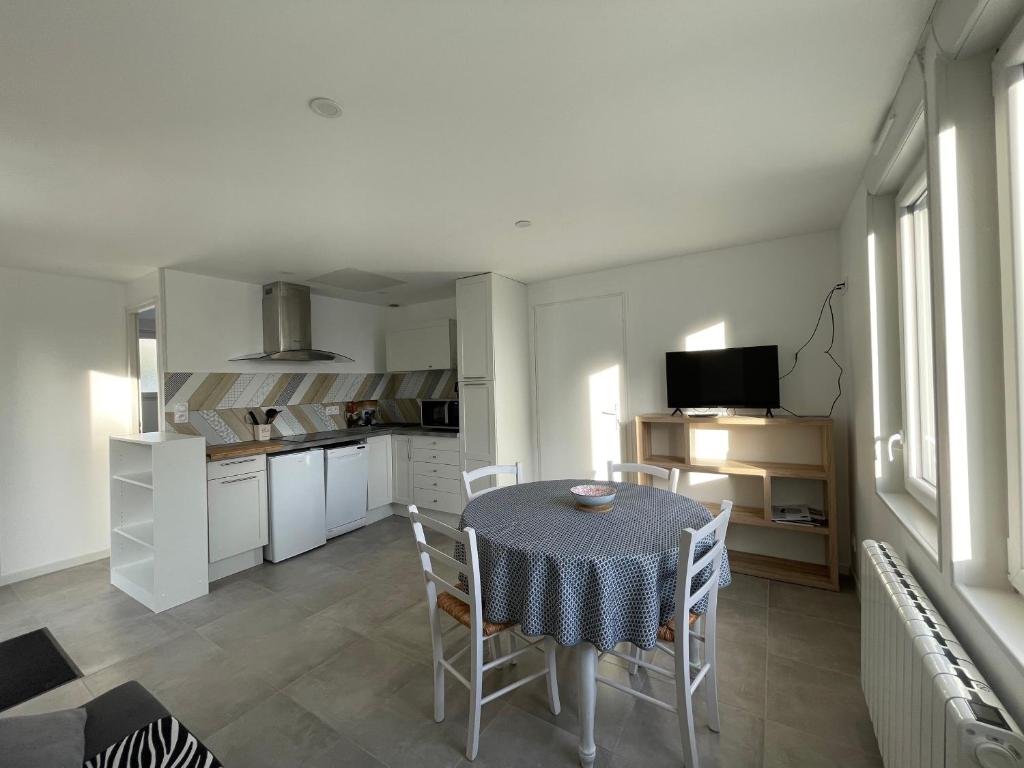 eine Küche und ein Esszimmer mit einem Tisch und Stühlen in der Unterkunft Héolia - Maison à 250m de la plage Damgan in Damgan