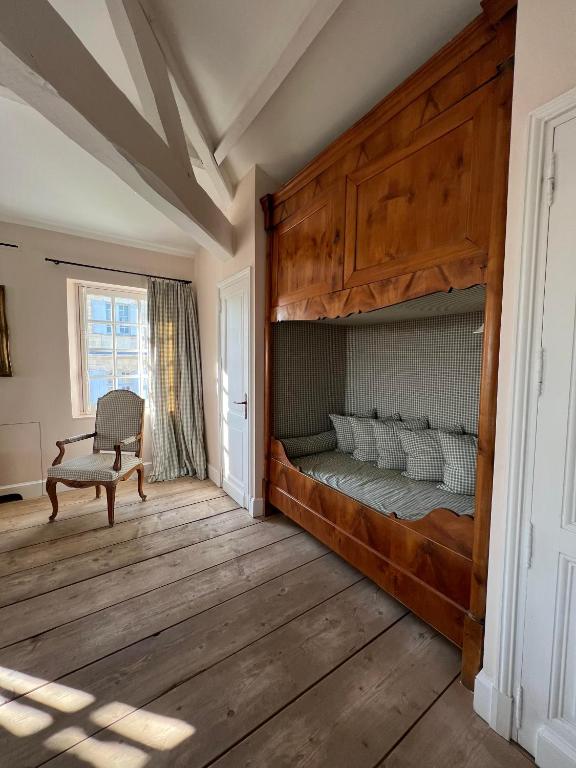 a bedroom with a bunk bed and a chair at Château du Tertre in Arsac
