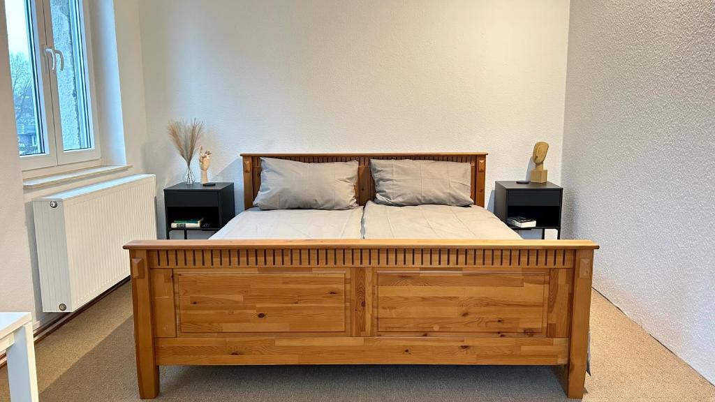1 dormitorio con 1 cama de madera y 2 mesitas de noche en Gemütliches Apartment en Gelsenkirchen