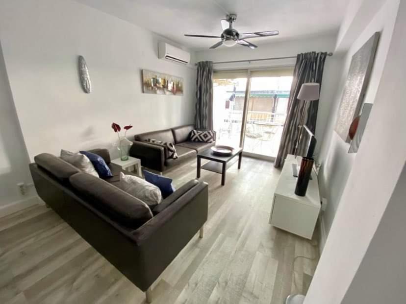 uma sala de estar com um sofá e uma mesa em Rainbow Rentals Marques 7 em Benidorm