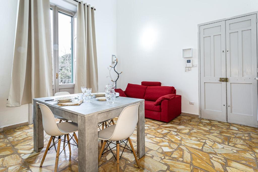 een woonkamer met een tafel en een rode bank bij La dimora di Santa Croce nel centro di Lecce in Lecce