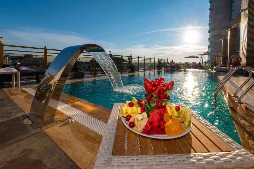 un piatto di frutta su un tavolo accanto alla piscina di Ramada By Wyndham Istanbul Pera Taksim a Istanbul