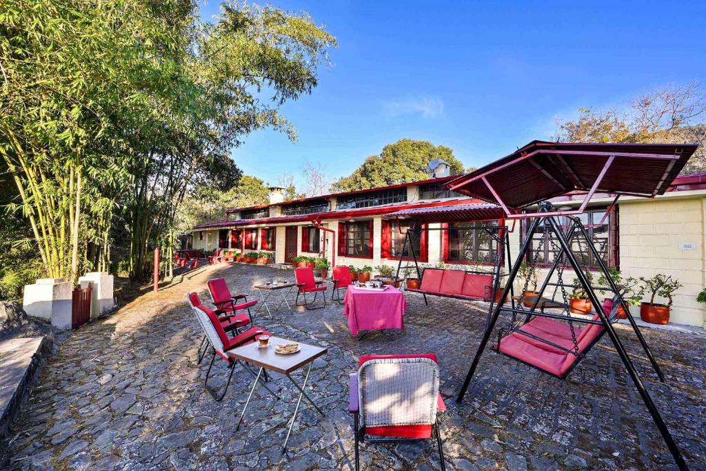 ein Haus mit roten Stühlen und einer Schaukel in der Unterkunft Oak Lodge 5BD Vintage Home in Bhowāli