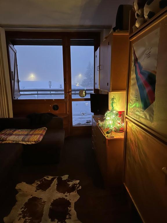 a room with two large windows and a table with a lamp at Sestriere Borgata appartamento in montagna Casa di Bertu in Borgata Sestriere