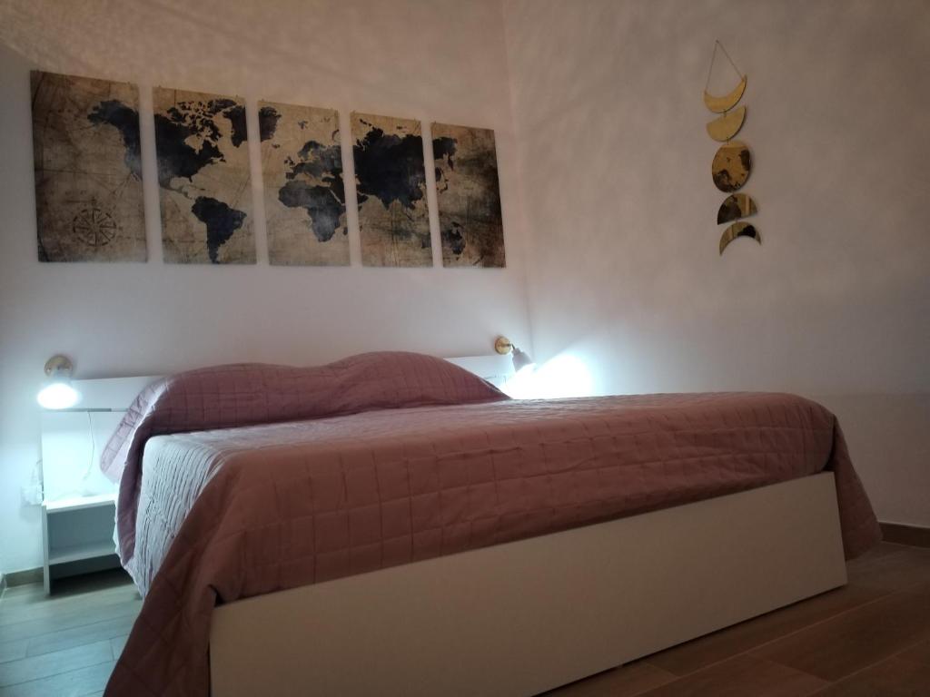 a bedroom with a bed with three pictures on the wall at Triremi house in Lido di Ostia