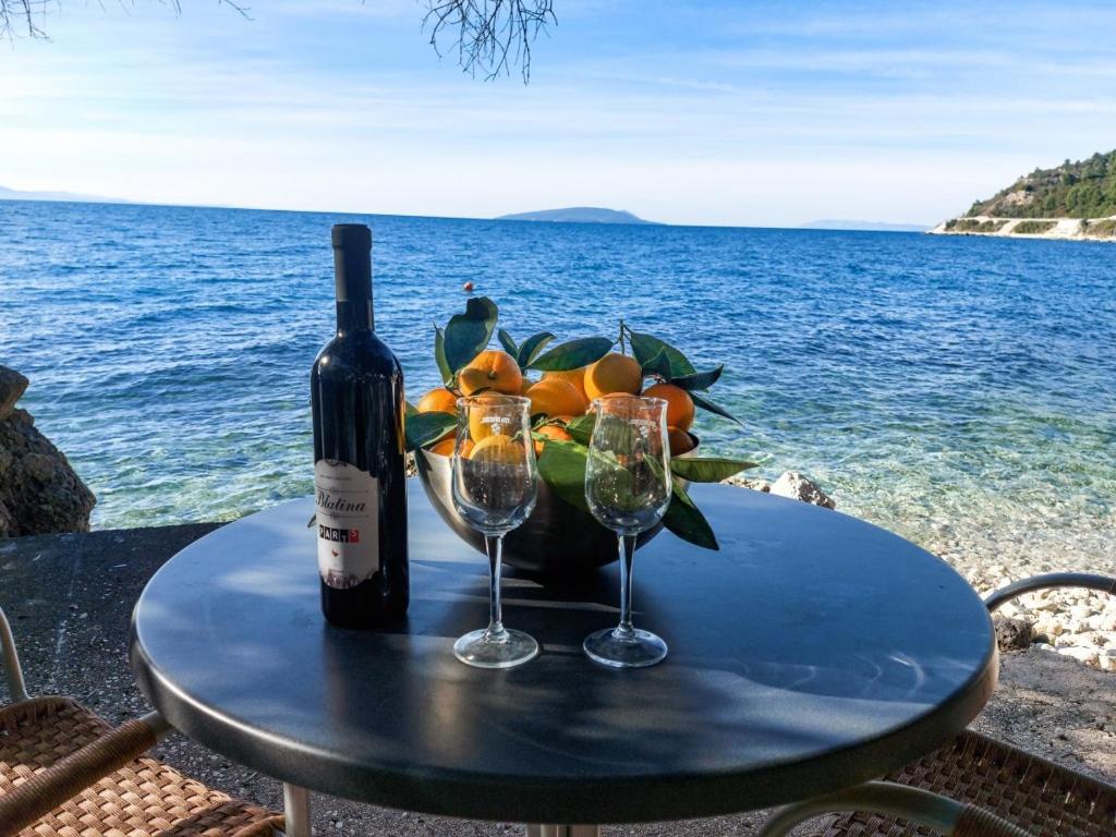 una mesa con una botella de vino y dos copas en Lemon tree en Podaca