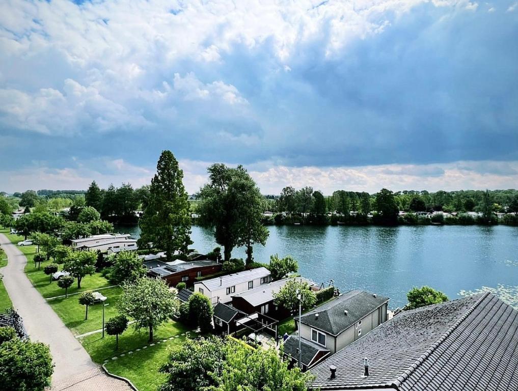 an aerial view of a lake with houses and trees at Recreatiepark de Markplas in Opheusden