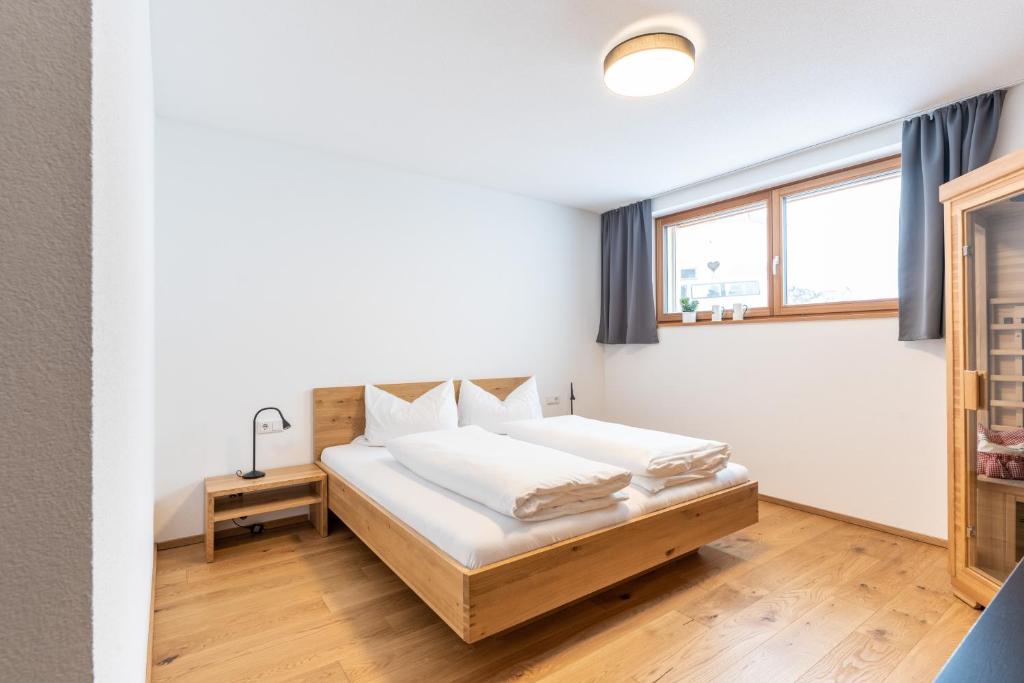Schlafzimmer mit einem Bett und einem Fenster in der Unterkunft Faschina Apartment - Top 1 in Fontanella