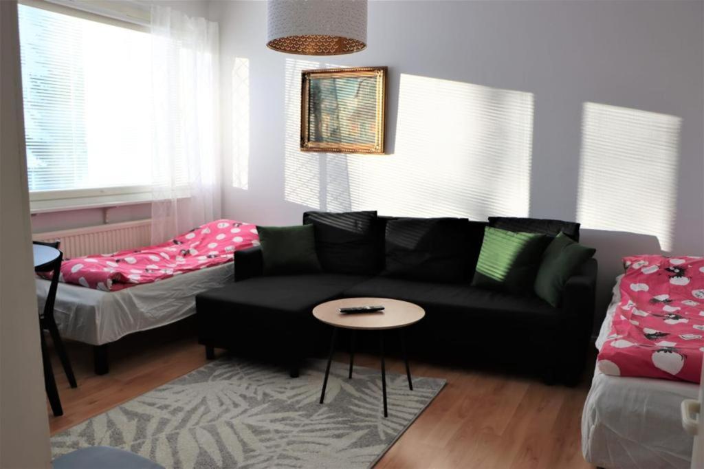 un soggiorno con divano nero e tavolo di Studio middle of town centre. a Tornio