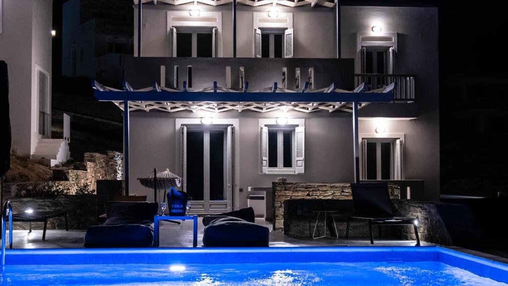 a house with a swimming pool at night at Antigoni Villas in Gavrio