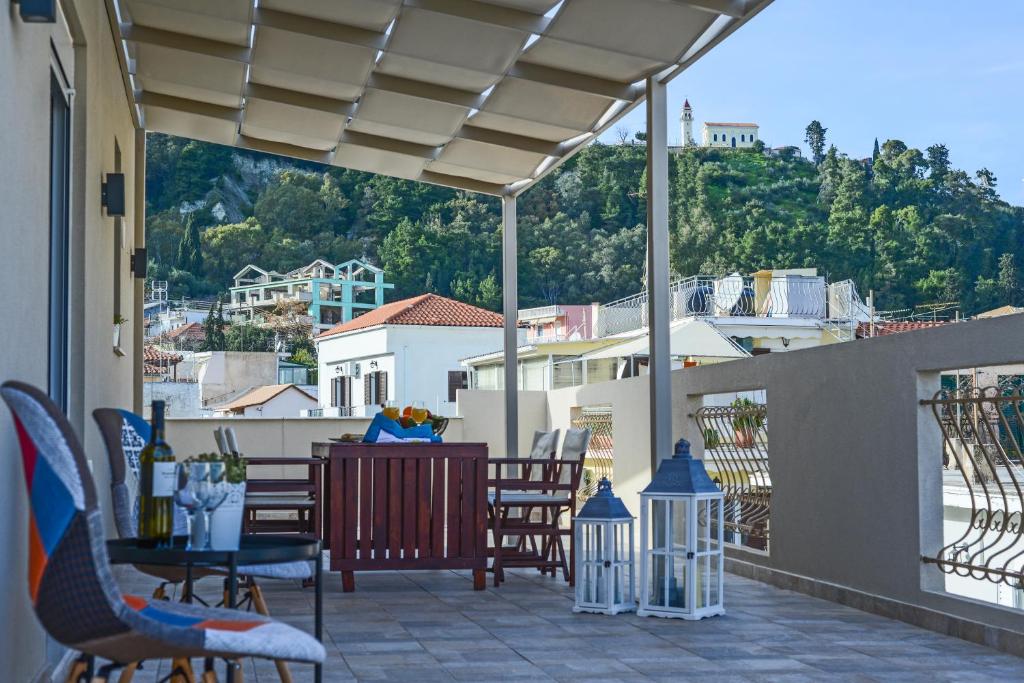 a patio with chairs and a table on a balcony at Victor Junior Suite in Zakynthos Town