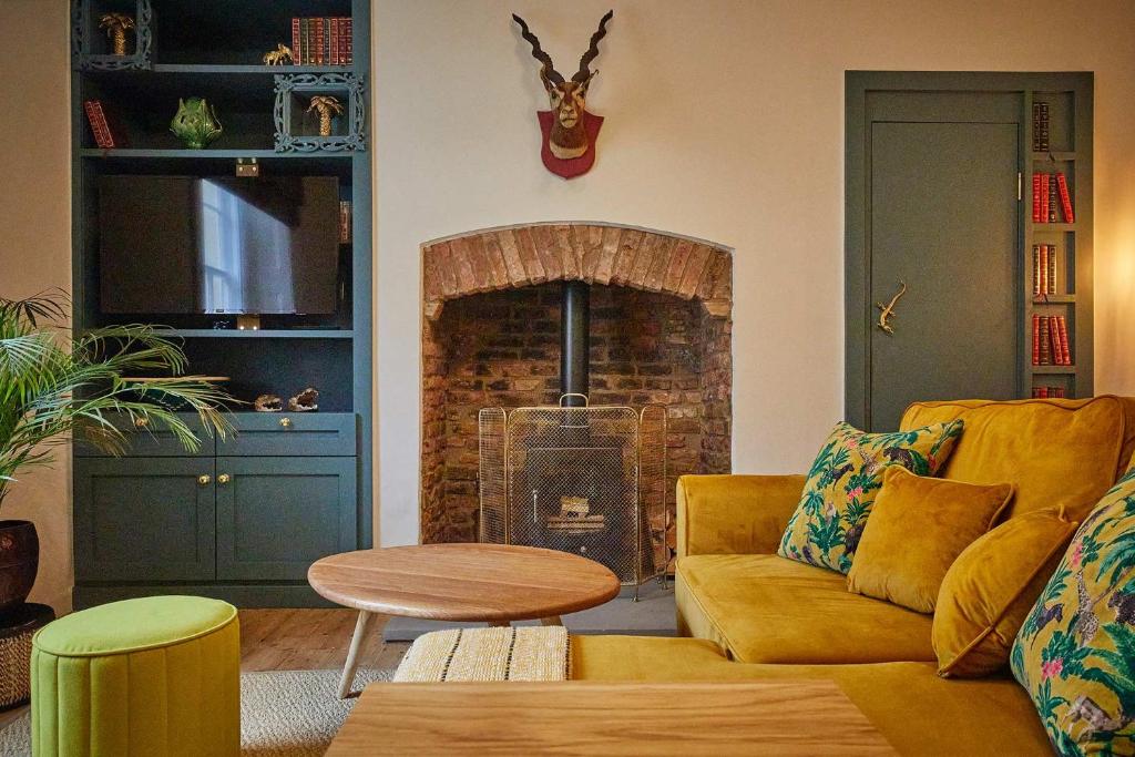 a living room with a couch and a fireplace at The Jungle Nook; Romantic Haven in Berwick-Upon-Tweed