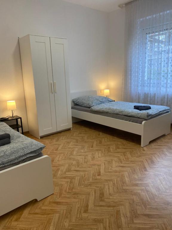 um quarto com 2 camas e piso em madeira em Monteurhaus Osnabrück Lüstringen em Osnabrück