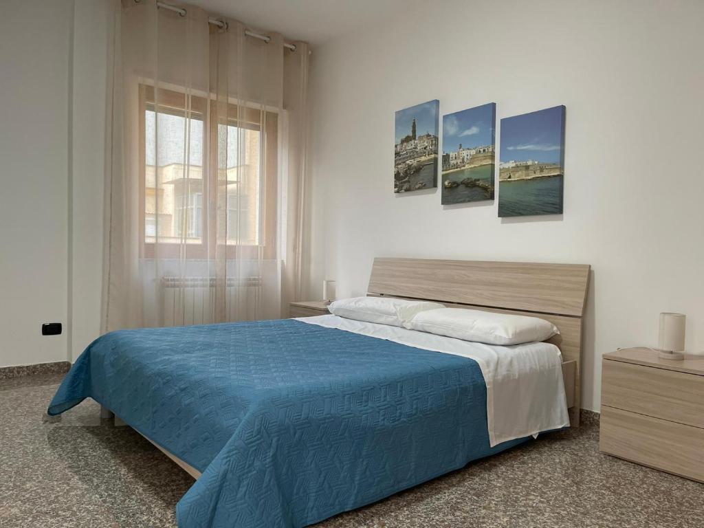una camera da letto con un letto grande con una coperta blu di Marval a Monopoli