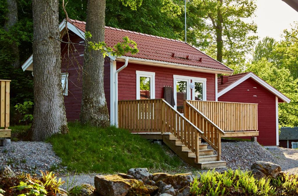 una casa roja con porche y escaleras delante en First Camp Sjöstugan - Älmhult en Älmhult