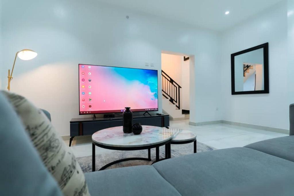 sala de estar con TV de pantalla plana grande en Palm Spring Luxury Apartment, en Port Harcourt