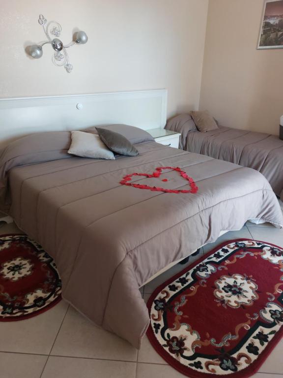 a bedroom with two beds and two rugs on the floor at Fiumicino Inn Airport in Fiumicino