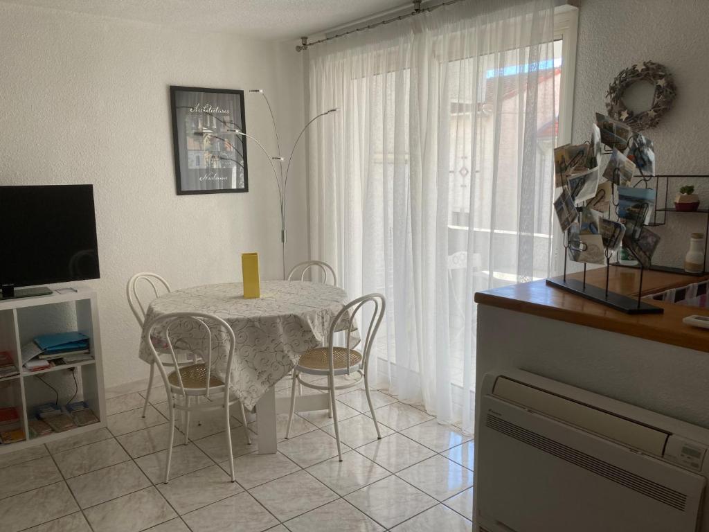 eine Küche mit einem Tisch und Stühlen sowie einem TV in der Unterkunft Appartement proche des halles in Narbonne