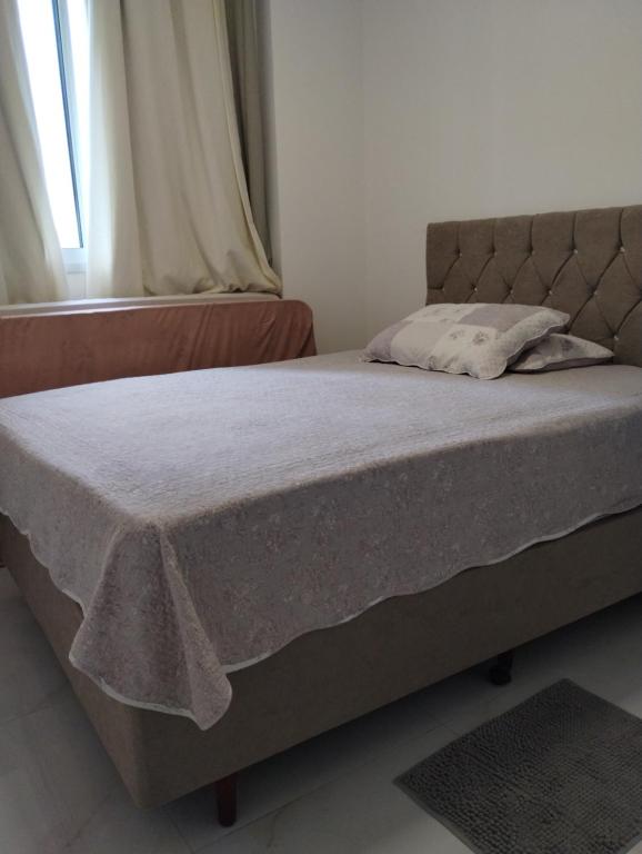 Una cama en un dormitorio con una manta. en Apartamento novo Gran Safira, en Itapema