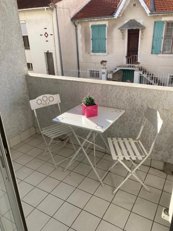 stół i krzesła na balkonie z rośliną w obiekcie Appartement proche des halles w mieście Narbona
