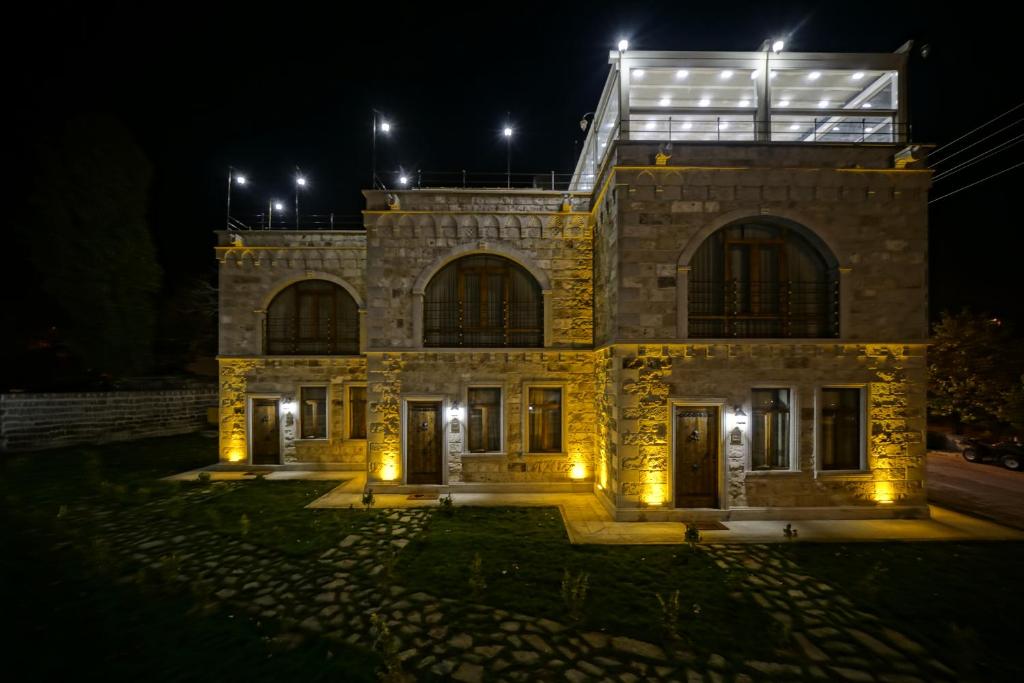 una casa de piedra por la noche con luces encendidas en Zultanite Cappadocia Hotel en Nevşehir