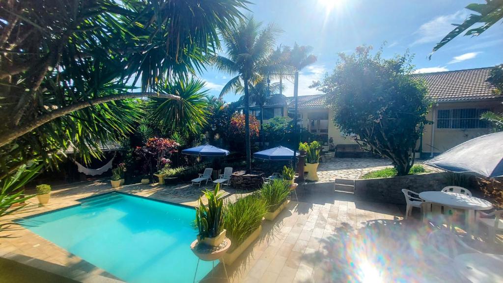 uma piscina num quintal com palmeiras em 3 Palmeiras Guest Lounge em Miguel Pereira