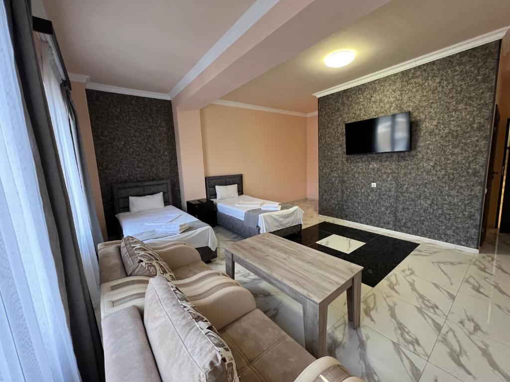 ein Hotelzimmer mit 2 Betten, einem Sofa und einem Tisch in der Unterkunft RP HOTEL (NEW) in Yerevan