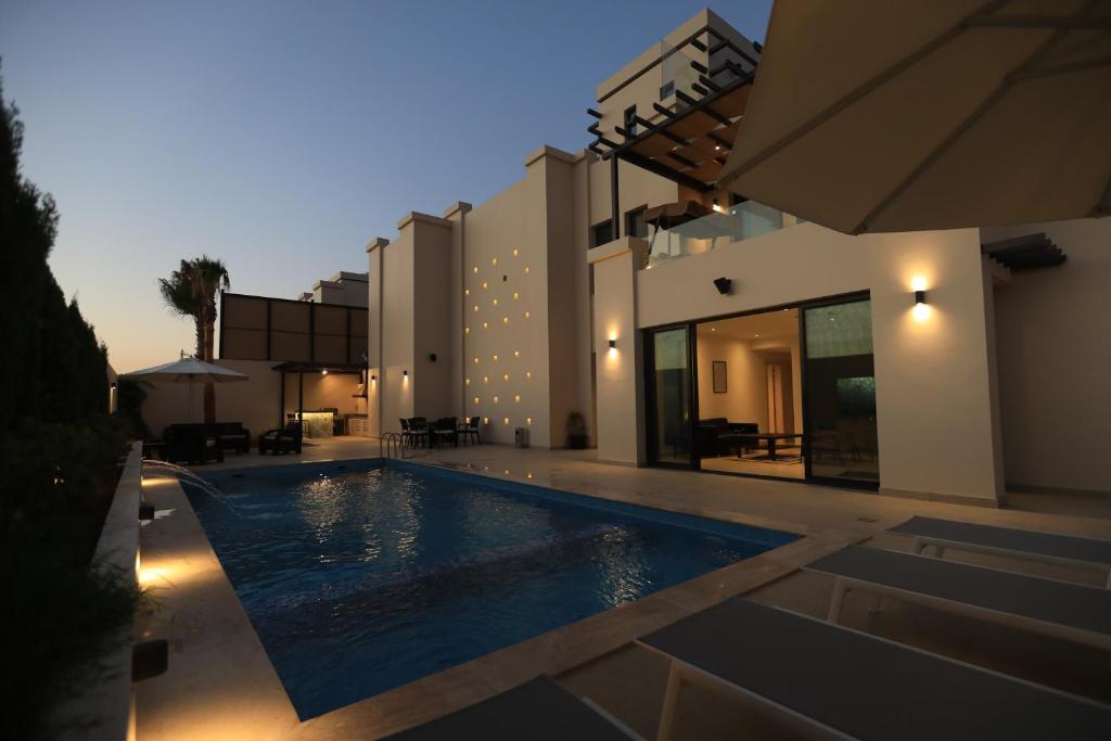 a swimming pool in front of a house at Zerø Føur DeadSea in Sowayma